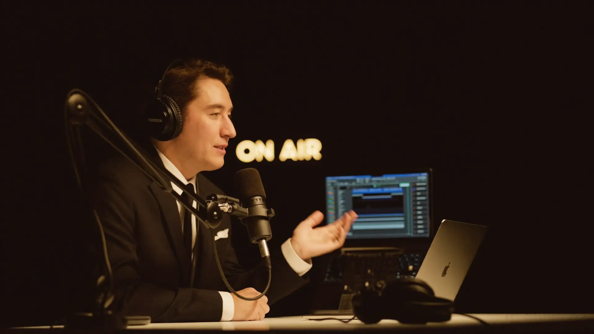 Radio presenter live at the desk under an ON AIR sign